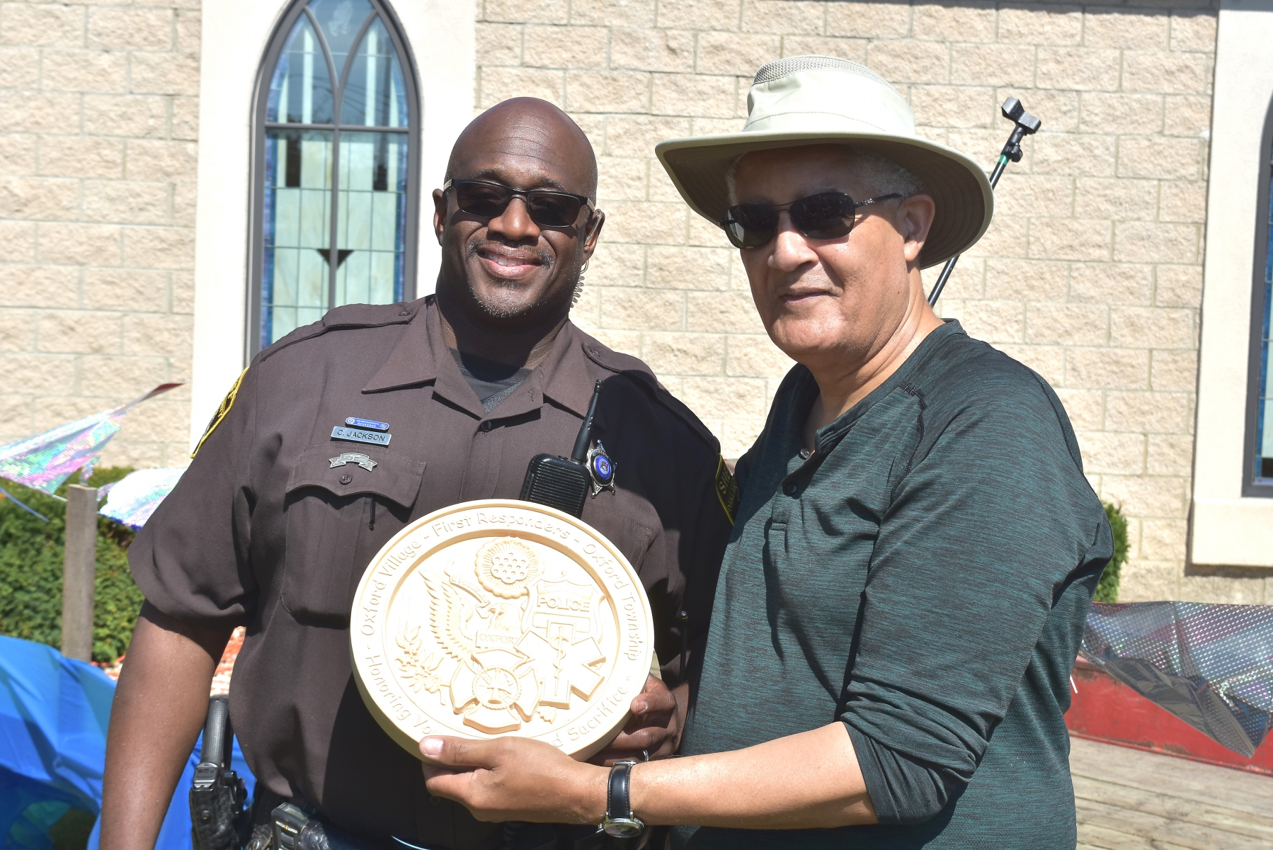 On-behalf-of-Oxford’s-sheriff-substation-Officer-Cary-Jackson-accepts-an-engraved-plaque-from-Oxford-UMC-pastor-Julius-E.-Del-Pino.-Photo-by-J.-Hanlon.