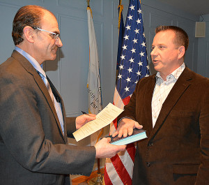 Erik Dolan (right), the newest member of the Oxford Village Council, receives the oath of office from township Clerk Curtis Wright. Photo by C.J. Carnacchio.