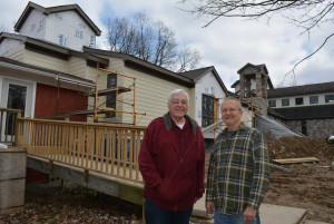 Fathers John Cochran (left) and Richard Herbel stand in front of the 9,000-square-foot building being constructed at St. Augustine’s House in Addison Twp. Photo by C.J. Carnacchio