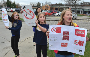 Oxford Elementary fifth-graders (from right) Ava Vogler, Carly DeTone and Emma Robinson staged an anti-smoking protest outside the school Friday afternoon in the hopes of convincing parents and passersby to kick the habit and live healthy. Standing behind them is OES teacher Stephanie Niemi. Photo by C.J. Carnacchio.