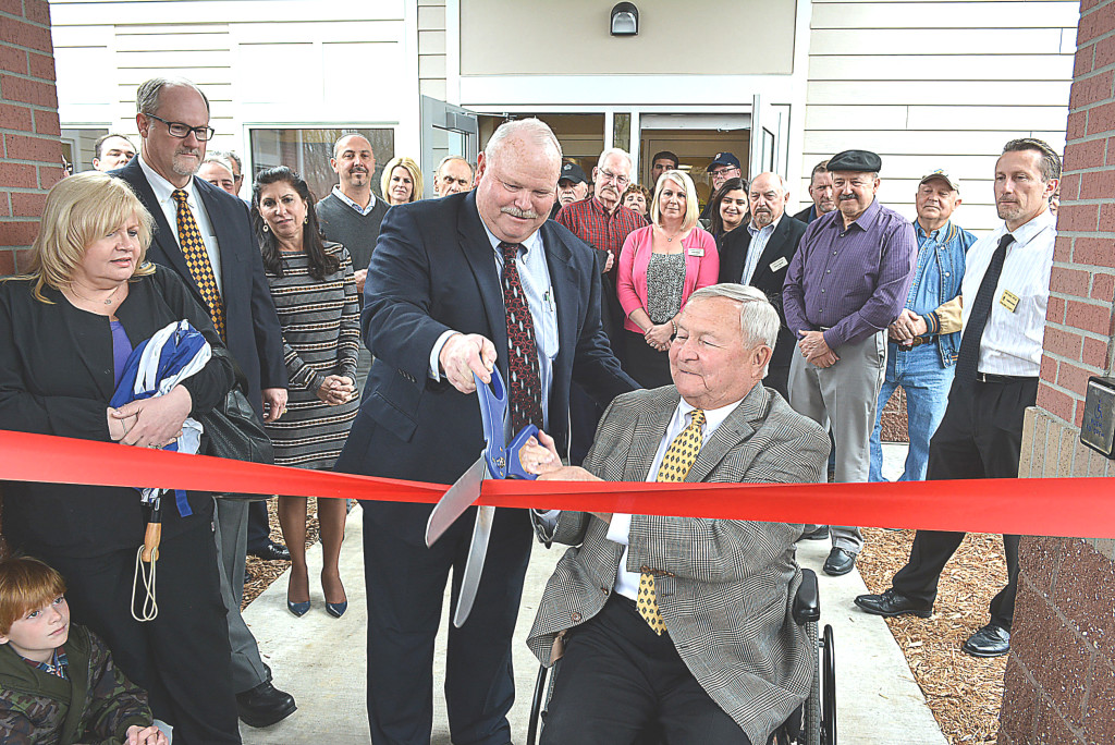 Addison Township Supervisor Bruce Pearson (center left) and Oakland County Executive L. Brooks Patterson cut the ceremonial ribbon at the April 28 open house for the township’s new 10,900-square-foot hall in Lakeville. Photo by C.J. Carnacchio.