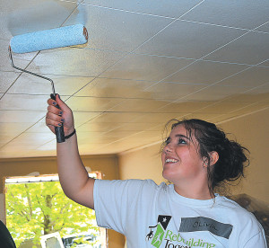 Olivia Morand, a resident of Pinconning, paints the living room ceiling. Her father is Bill Morand, the northeast region communications director for Charter Communications.