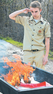 Life Scout Julian Messina salutes Old Glory as it’s consumed by the ceremonial fire. Photo by C.J. Carnacchio.