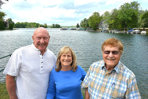 Lakeville Lake property owners (from left) Chuck Sargent, Sue Weatherhead and Paul Woodring are helping to organize a boat parade on Saturday, July 2. Anyone with a gasoline-powered boat is welcome to participate and cruise the 460-acre lake in Addison Township. Photo by C.J. Carnacchio.