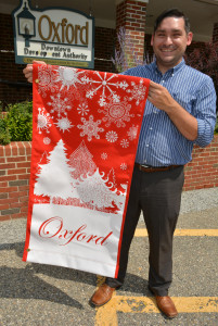 Oxford DDA Executive Director Joe Frost shows off one of the 24 holiday-themed banners purchased for display in the downtown area. Photo by C.J. Carnacchio.