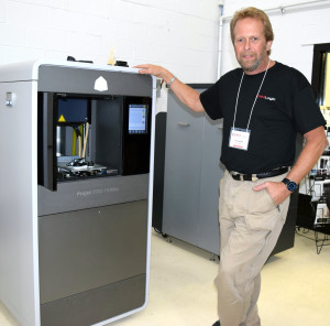 Jim Carlisle, president and owner of CAM Logic, stands next to one of his state-of-th-art 3D printers. Photo by Elise Shire.