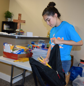 OHS freshman Melia Tenorio-Pindter fills a brand new backpack with school supplies. Photo by Elise Shire.