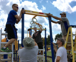 Volunteer Chad Umscheid and Community Build Supervisor of Miracle Midwest Juan Bradford balance the new monkey bars.