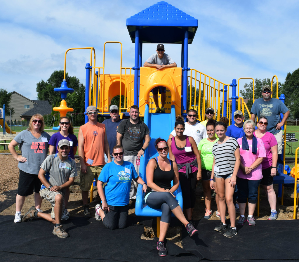 Volunteers from day two's "build team" stand in front of Lakeville Elementary's new playground. Photo by Elise Shire.