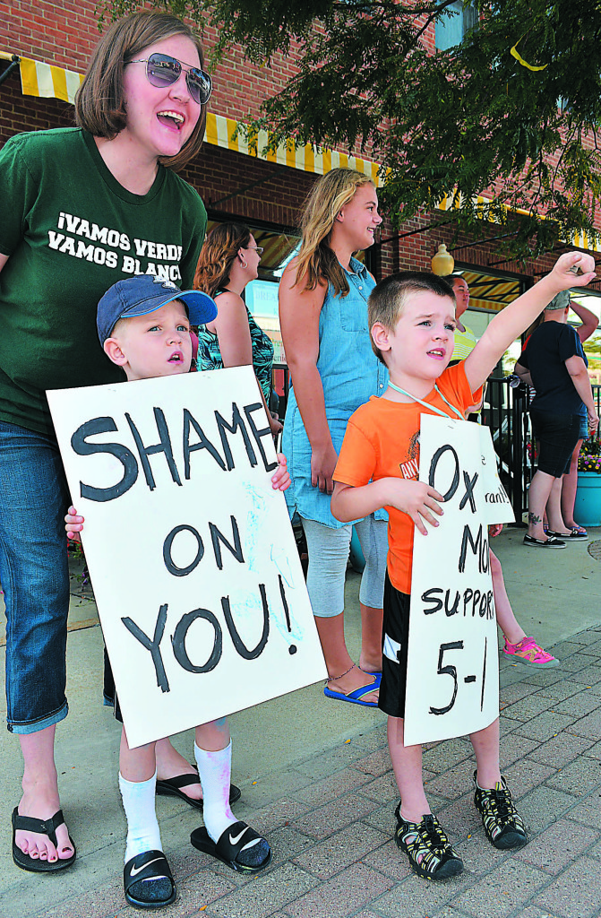 Oxford resident Katie Rose protests outside downtown's 5-1 Diner with her sons Jack, 5, and Liam, 3. Photo by C.J. Carnacchio.