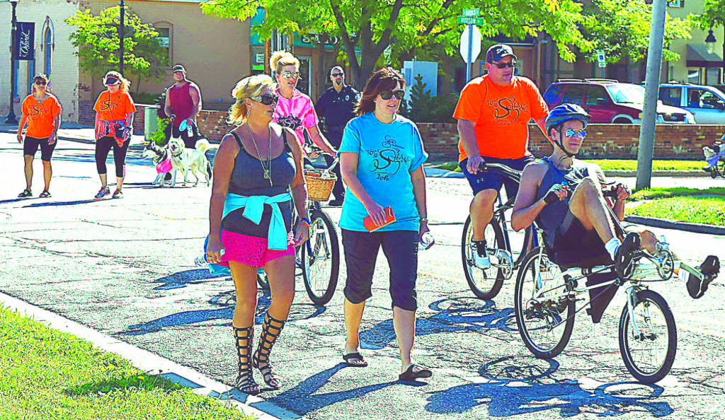 People from near and far biked and walked down W. Burdick Street to honor the memory of Shane Hrischuk. Walking in front (to the left) is his mother, Michelle.