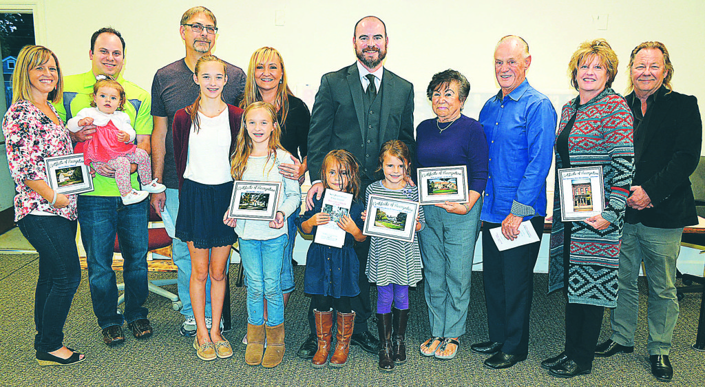 2016 Beautification Award winners (from left) Adam and Kristi Wiegand (53 Dennison St.) with their daughter Madison Michelle, 1; John Dillon and Lynn Middleton (51 W. Burdick St.) with their daughters Katherine, 14, and Jacqueline, 11; Kevin Lynch (Lynch & Sons Funeral Directors, 39 W. Burdick St.) with his daughters Livie, 5, and Addison, 7;  Evelyn and Charles Brett (640 Lakes Edge Dr.); and Betty and Mark Young (Mark A. Young Jewelers, 31 N. Washington St.). Four winners were not present for the ceremony – Jose and Rosemary Rivera (496 Sunset Blvd.), Larry and Shari Berklich (75 W. Burdick St.), Dave and Jill Powers (46 First St.) and Steven Wolf (Oral & Maxillofacial Surgery, 113 N. Washington St.). Photo by C.J. Carnacchio.