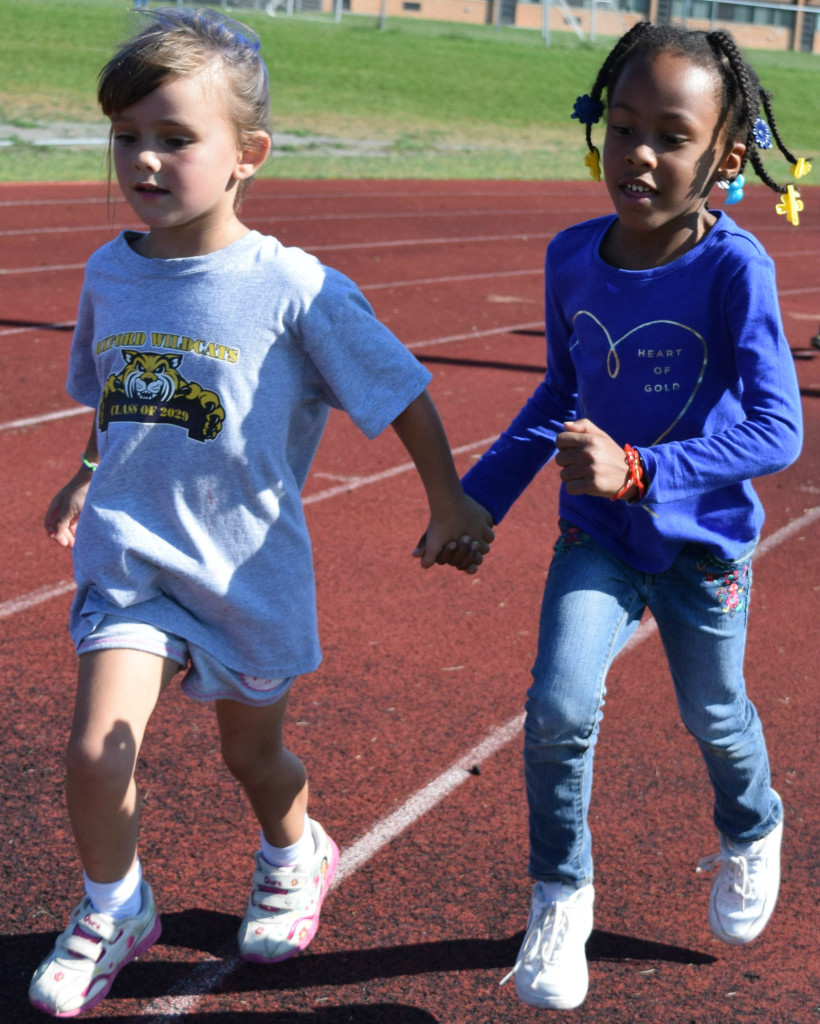 Daniel Axford students Grace Lally (left) and Madison Walton make their way around the track together, encouraging each other with every step.