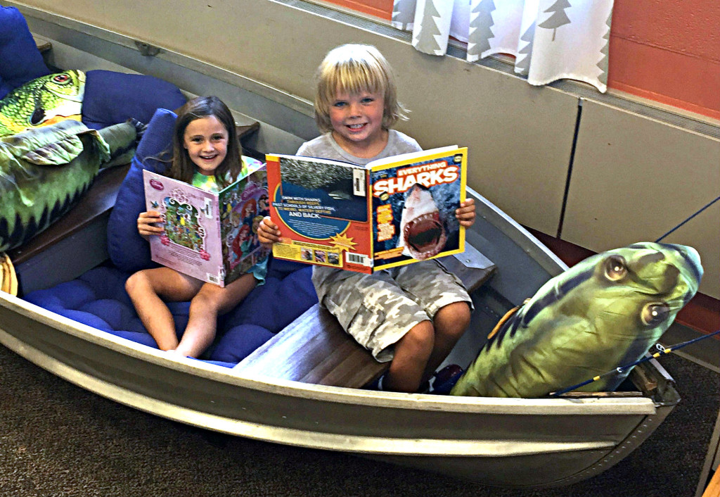 Students Lelynn Slanec (left) and Scott Houck do some reading in the new row boat in the Leonard Elementary School library. Photo provided.
