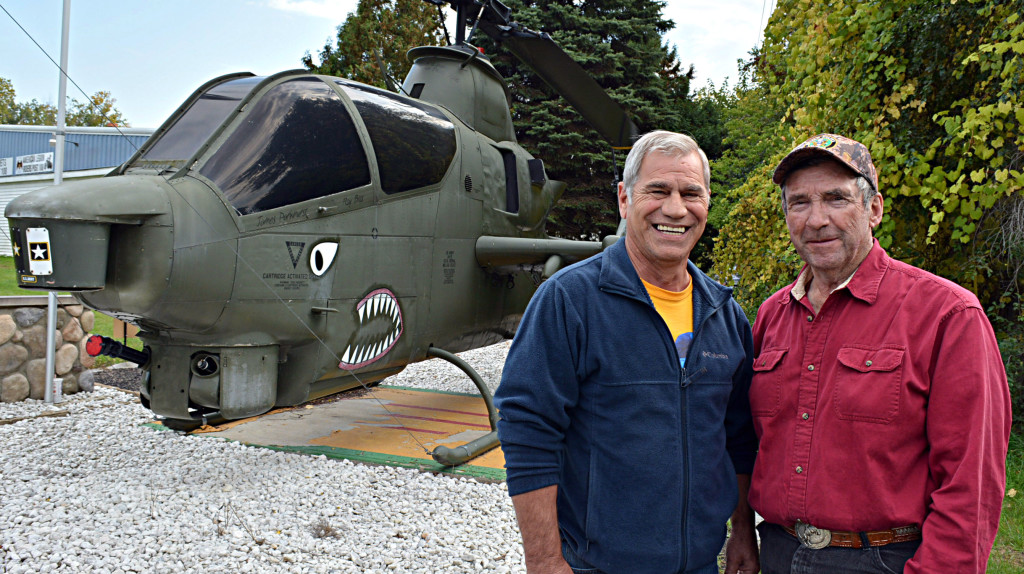 Rick Moorhead (left), commander of Oxford American Legion Post 108, and Jim Parkhurst, curatoe of the post's military museum, stand in front of post's iconic AH-1 HueyCobra attack helicopter. More than 1,100 of these choppers were built and they racked up more than one million flight hours with the U.S. Army in Vietnam. Photo by C.J. Carnacchio.