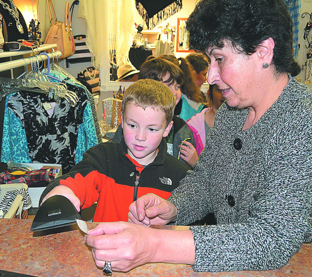 Aiden Minke (left) learns how to use a scanning gun at Boulevard Boutique, a consignment shop in downtown Oxford, with some assistance from employee Mary Yasso. Photos by C.J. Carnacchio.