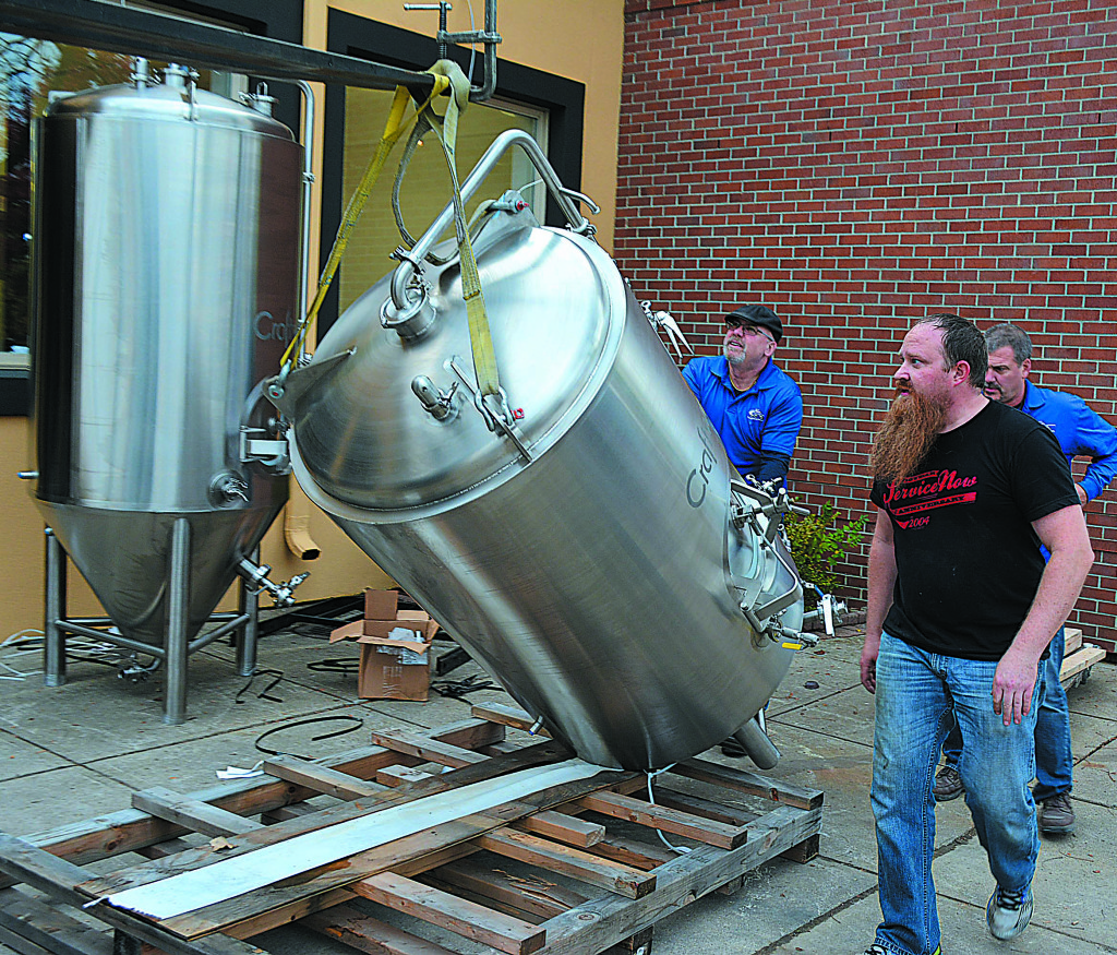 George Lang, co-owner of Falling Down Beer Co., supervises the installation of the 12 brewing, fermenting and brite tanks for the Oxford brewery. Photo by C.J. Carnacchio.