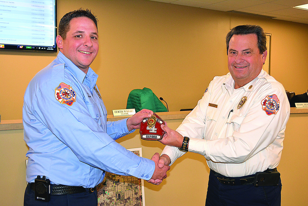 Oxford Fire Sgt. Benjamin Frantz (left) receives his new leather helmet shield from Fire Chief Pete Scholz. Photo by C.J. Carnacchio.