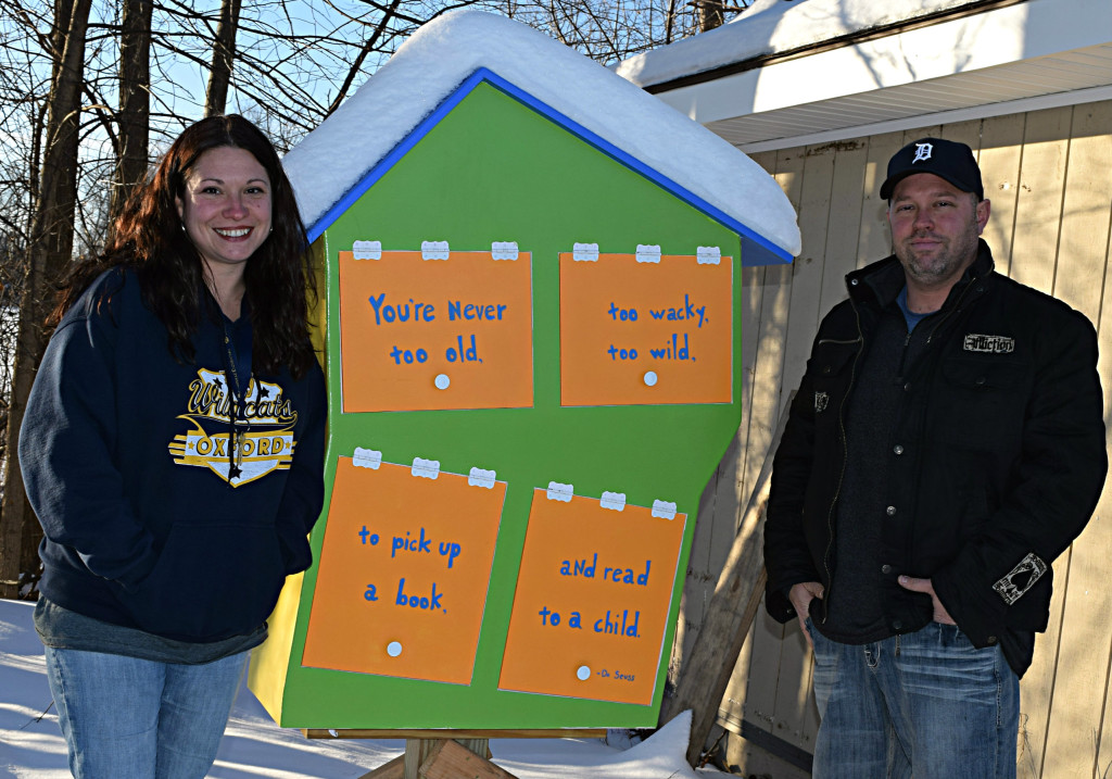 Michelle Candella (left) and Michael Audia pose next to the Little Free Library they erected in the Lake Villa Manufactured Home Community. Photo by Elise Shire. 
