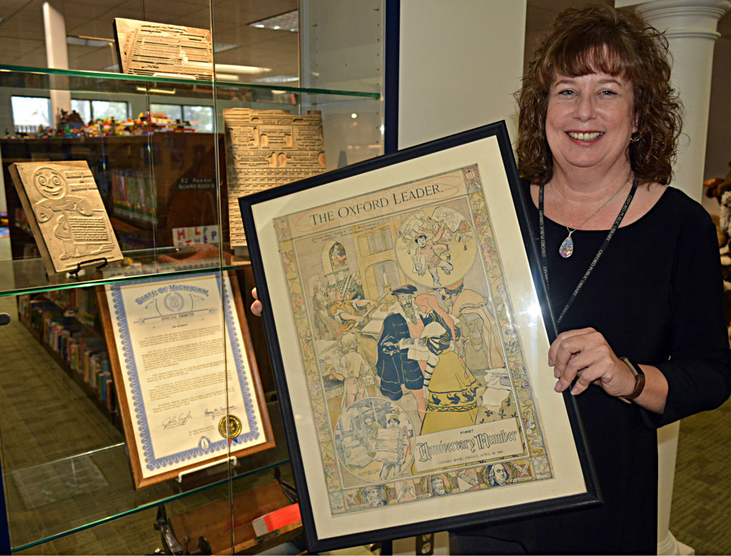 Sandy Gilmore holds a copy of the Oxford Leader's one-year anniversary cover from April 1899. Photo by C.J. Carnacchio.