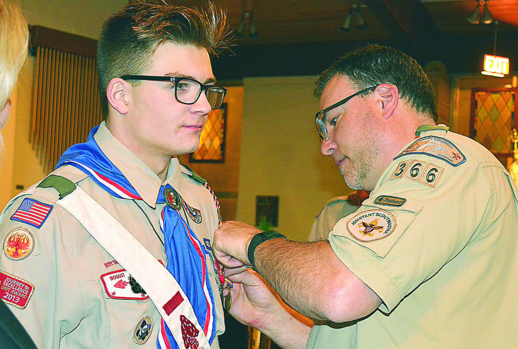 Oxford resident Brian Sabo (right) pins the Boy Scouts of America’s (BSA) Medal of Merit on the chest of his son Trenton Sabo, an Eagle Scout. Photo by C.J. Carnacchio.