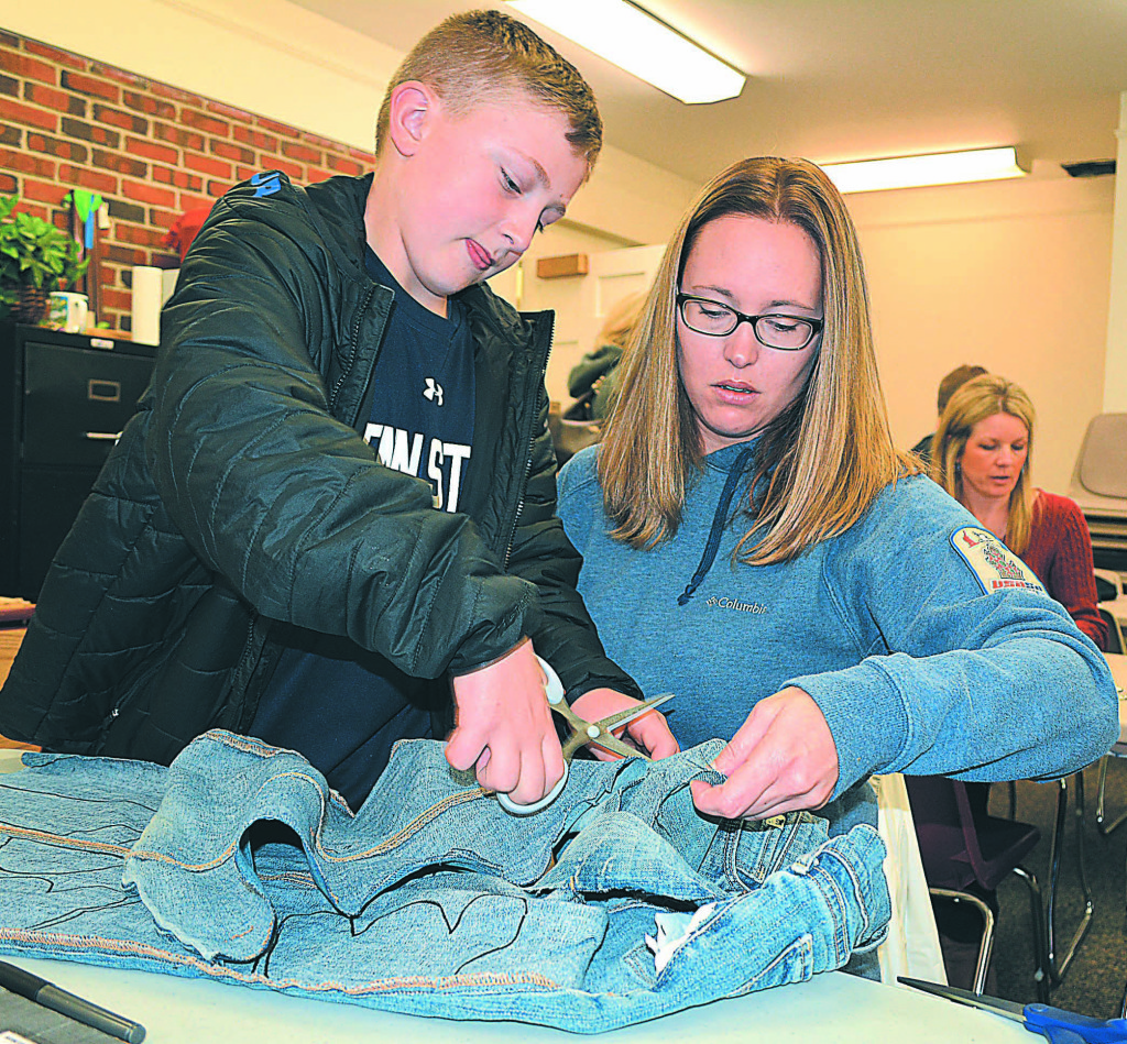 Abby Allen assists her son, Carter Kitchen, a fifth-grader at Oxford Elementary, at the cutting table.