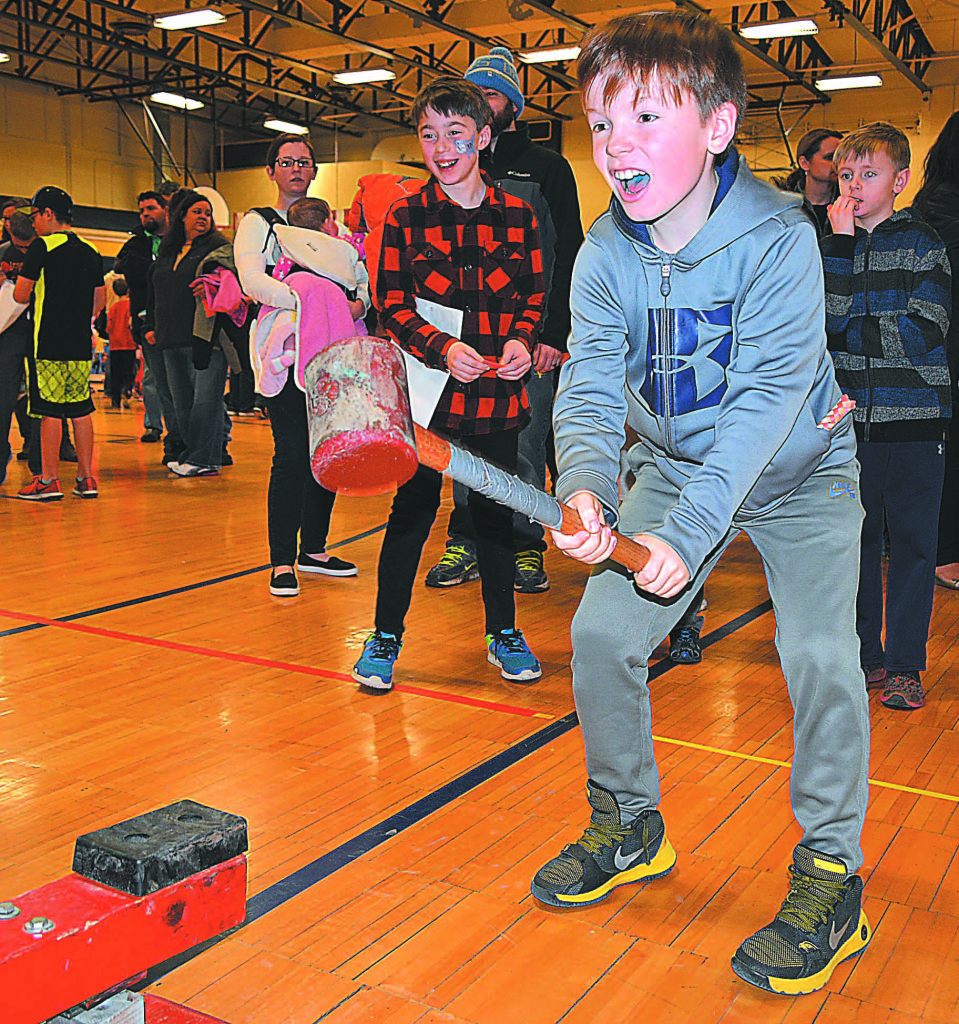 Testing his muscles by playing the traditional strongman game is OES fourth-grader Ethan Kussner.
