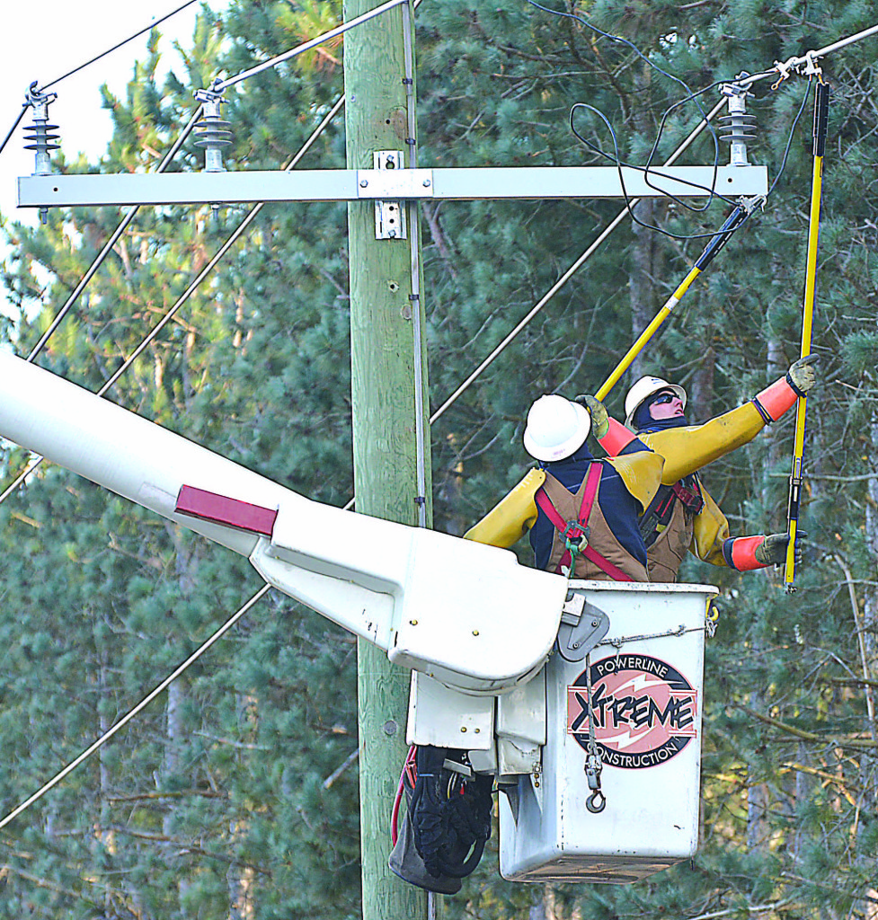 Workers finish installing a new power pole just east of Dunlap Rd. and just north of the Oxford Township Hall.