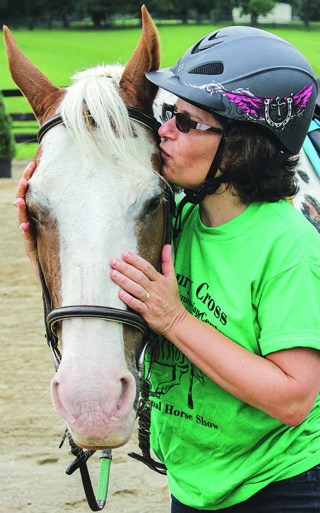 Addison Township resident Joan Baldiga gives Doodle Bug, one of the horses at Banbury Cross Therapeutic Equestrian Center in Metamora, a kiss. “Words cannot express how grateful I am to these animals, but a picture can,” she said. Photo by Captured Hope Photography.