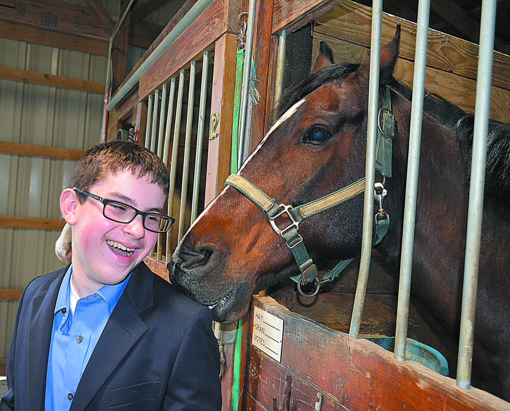 Star Student Rider John Paczkowski, a sixth-grader at Scripps Middle School in Orion Township, shares some laughs with Malabar, one of the horses at the Banbury Cross Therapeutic Equestrian Center in Metamora Township. Photo by C.J. Carnacchio.