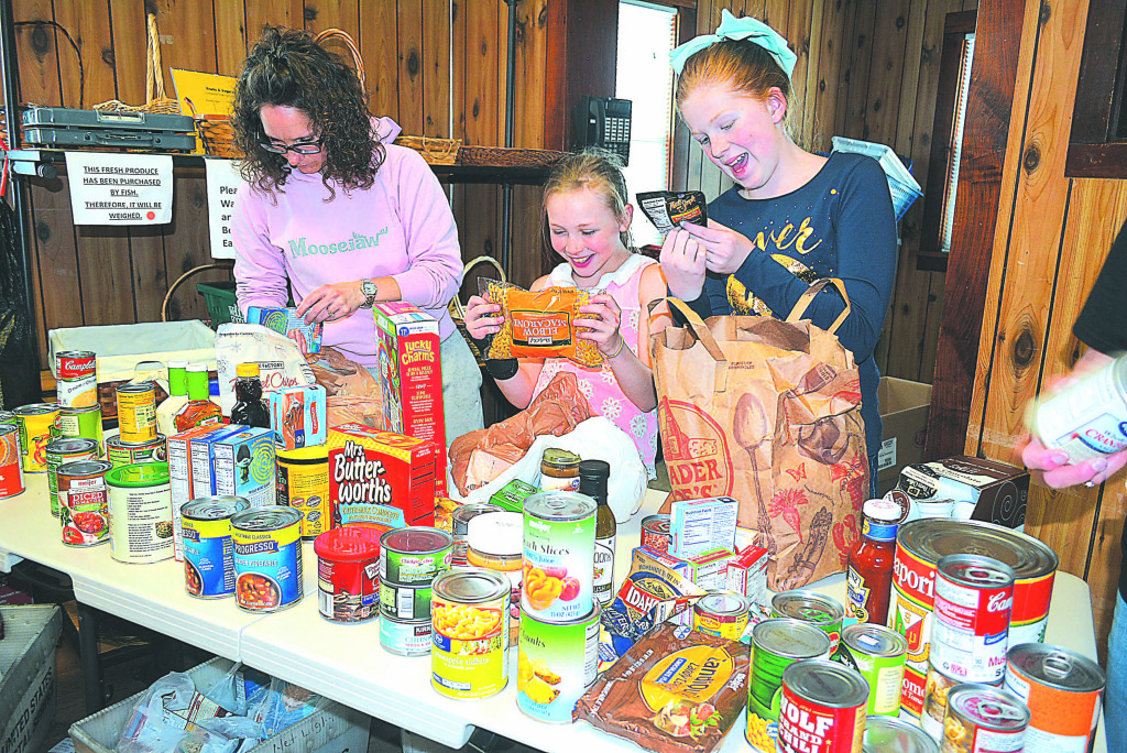 Checking the expiration dates of the donated food are Kingsbury Country Day School fifth-graders Zoe Fleischer (far right) and Amelia Stewart (center). With them is Amy Dymond, of Oxford. Photo by C.J. Carnacchio.