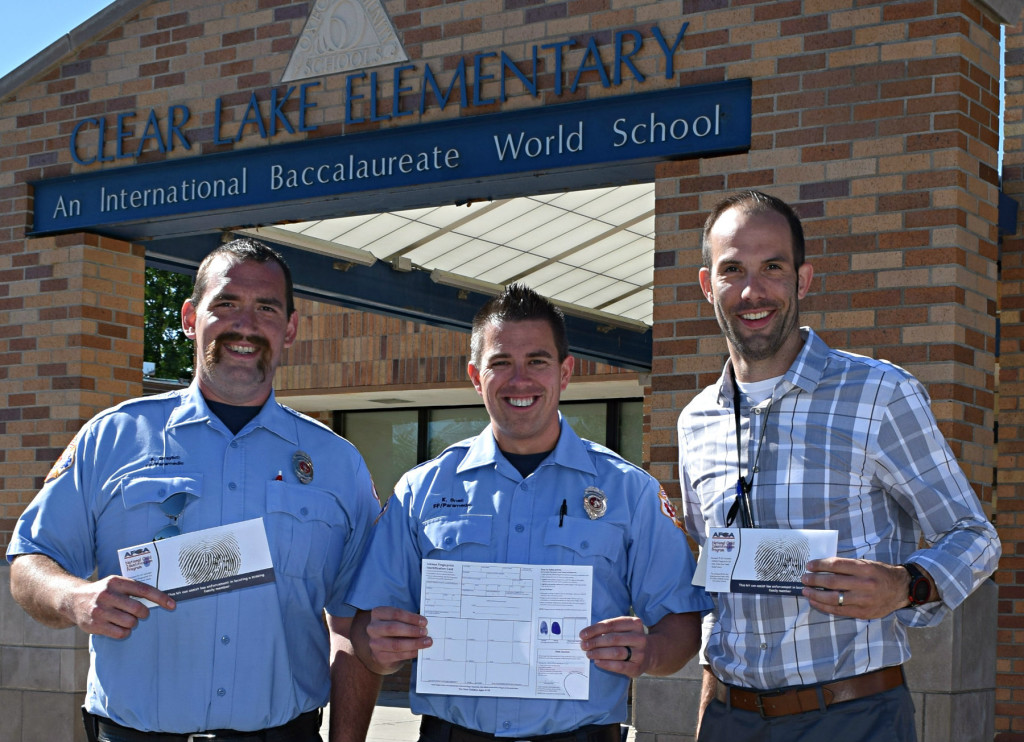 Oxford Fire Fighters Union Vice President Anthony Graybill (left to right), President Kevin Snell, and Clear Lake Principal Brad Bigelow pose with Child ID kits. A total of 2,500 kits were donated to Oxford’s elementary schools. Photo by Elise Shire.