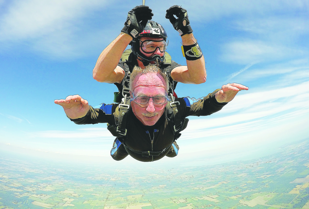 Bill Dunn in freefall, rushing toward the ground at 120 miles per hour. On his back is skydiving instructor Phil White. Photo courtesy of Midwest Freefall Skydiving.