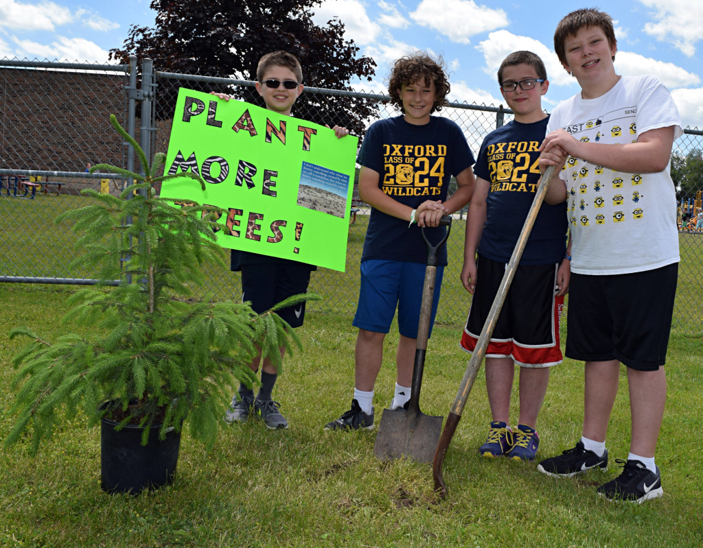 Lakeville fifth-graders Bishop Dissmore (from left), Jay Cady, Collin Rogers and Adam Harville are making a difference in the world one tree at a time. Photo by Elise Shire.