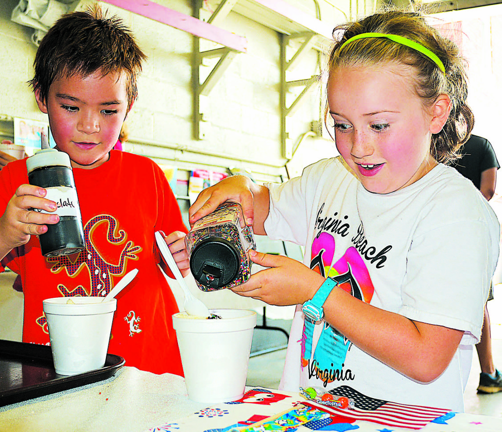 Adding sprinkles and chocolate sauce to their ice cream sundaes are Oxford resident Corinne Knight (right) and her cousin Ethan Elsholz, also of Oxford. Both attend Clear Lake Elementary School.