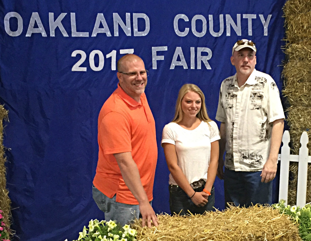 Manager of Oxford Farm & Garden Dennis Smith (left to right) poses with Sarah Liford and Owner of Oxford Farm & Garden Scott Sluiter at the 4-H Fair poulty auction, held July 14. Photo submitted.