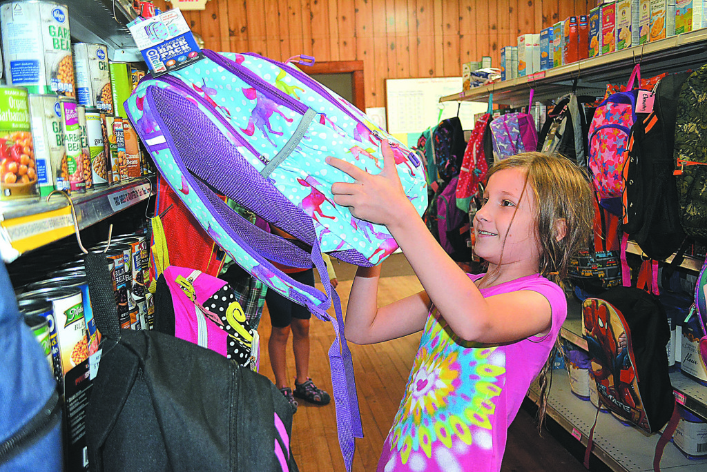Andrea, an Oxford fourth-grader, checks out the selection of brand new backpacks  at the Oxford-Orion FISH pantry. Photo by C.J. Carnacchio.
