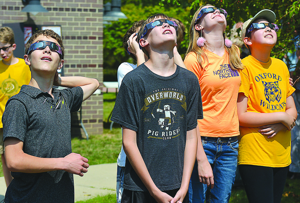 Viewing the eclipse through glasses with solar filters are (from left) Liam Zelenock, Kaleb Gordon, Ava Gordon and Katherine Lewis. Photos by C.J. Carnacchio.