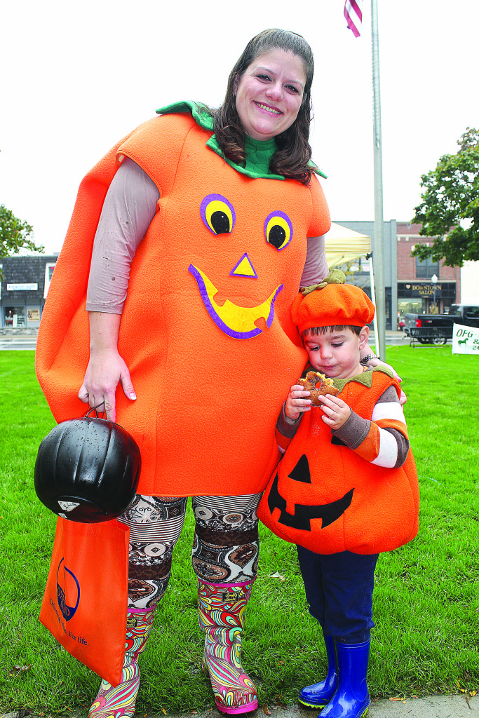 Dressed as jack-o’ lanterns are Oxford resident Lorry Graybeal and her son Scot, 3. She wanted him to smile for the camera, but he was more interested in eating the doughnut. Photo by C.J. Carnacchio.