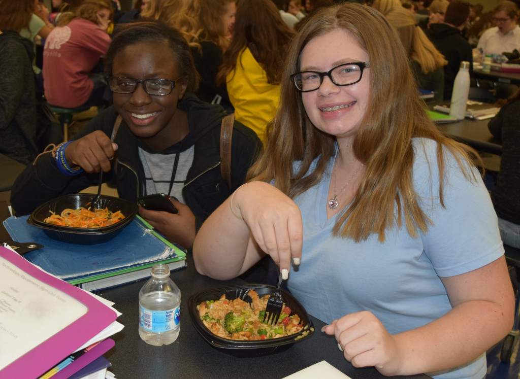 Sophomores Ciera Richardson and Isabelle Acheson enjoy stir-fry during the OHS International Food Festival. Photo by Elise Shire.