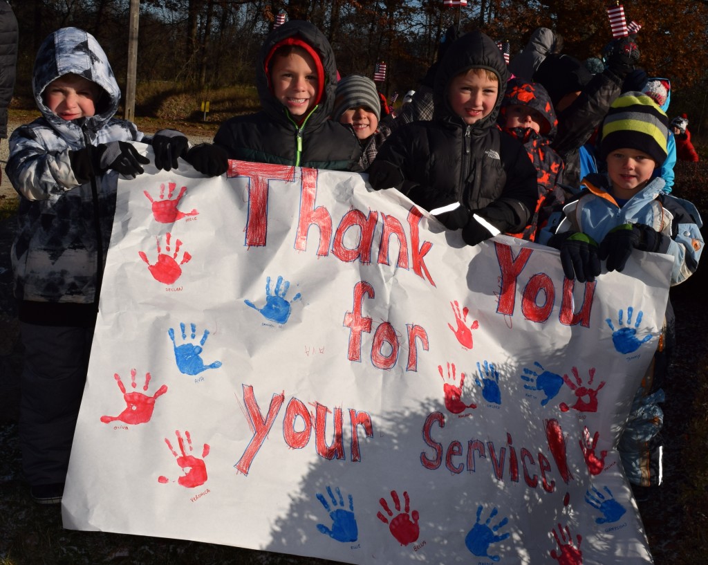 Holding a sign thanking veterans for their service are (from left) Kingsbury students Declan Saunders, Alec Dubey, Noah Griffith, and Tommy Rascher. Photo by Elise Shire.