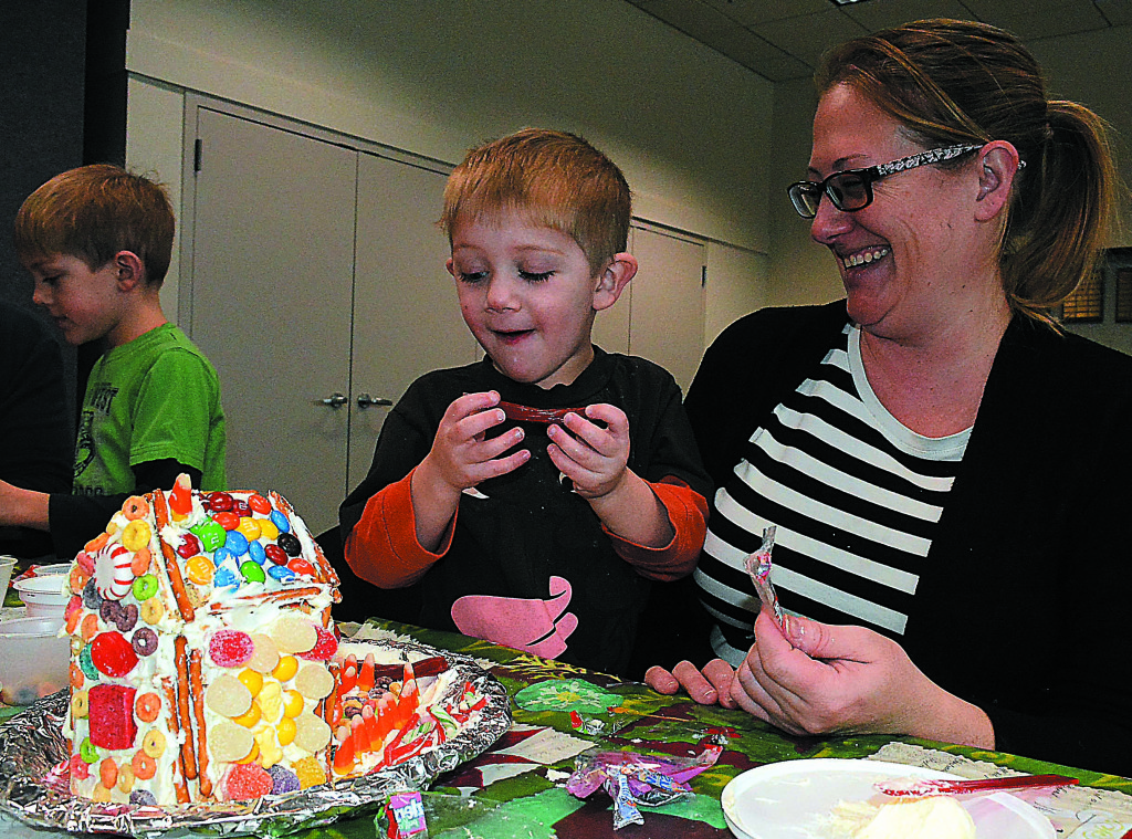 Bennett Bergeron, 4, of Oxford, builds a gingerbread house with his mother, Amy.
