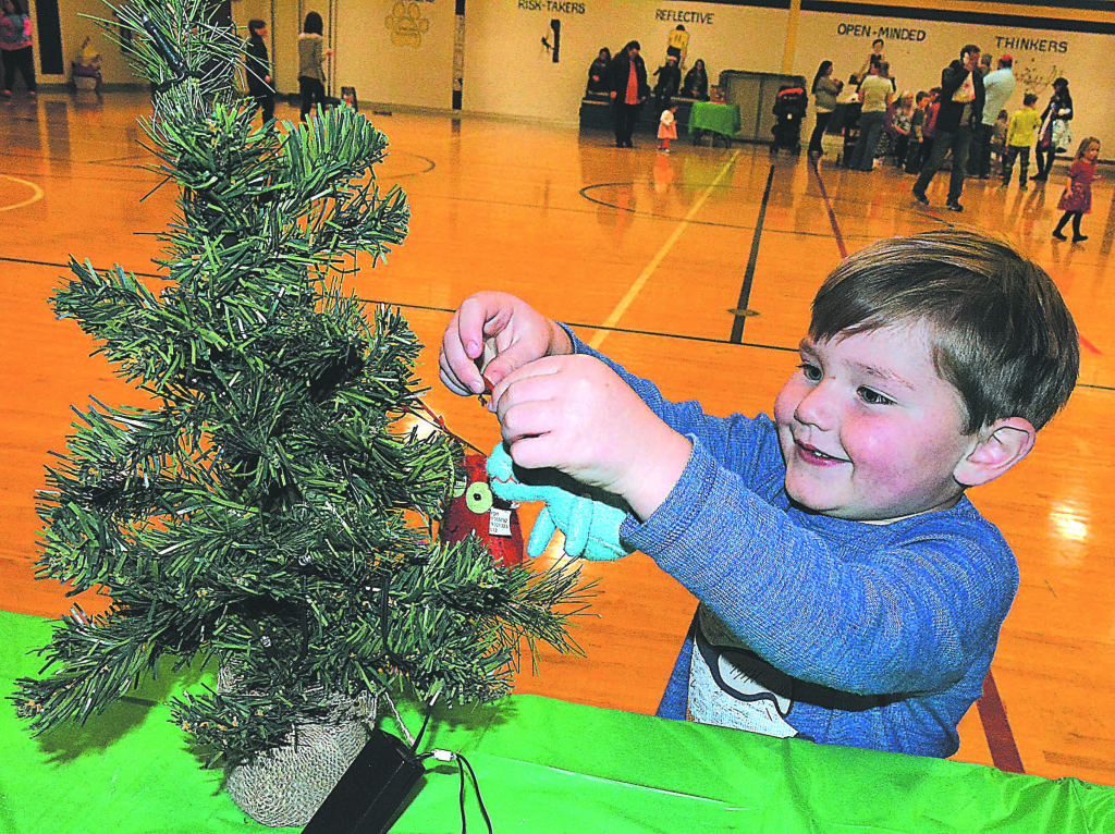 Luke Schutz, 3, of Oxford, participates in the Christmas tree decorating relay race. Photo by C.J. Carnacchio.