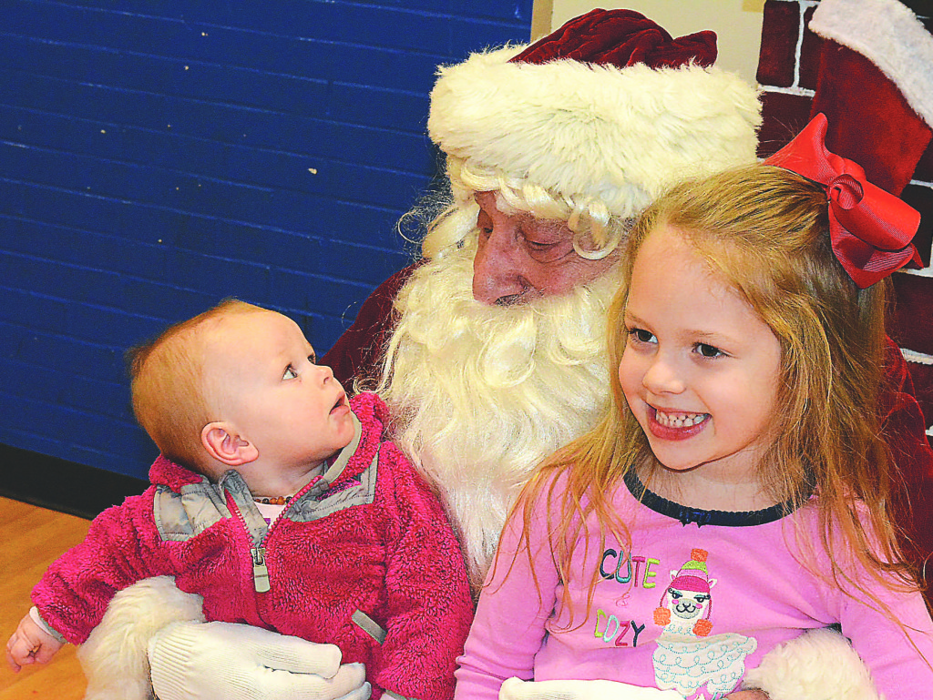 Little Alaina Holland, who’s just 8 months old, was quite fascinated by this old guy with the long white beard. Her sister, Aria Holland, a kindergartner at Leonard Elementary is an old pro. She knew to just smile for the camera when you meet Santa. Photo by C.J. Carnacchio.