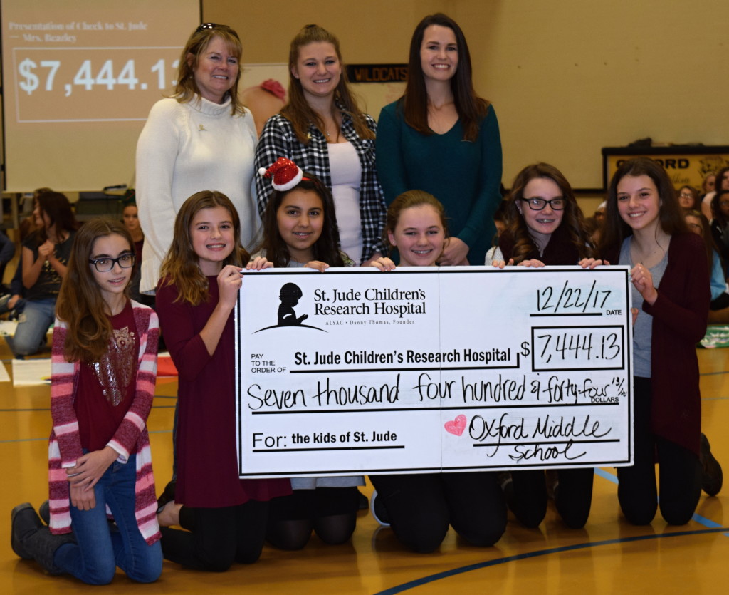 Volunteer Toni Casey (back row, from left) Intern Brianna Patrick and Senior Regional Representative Nicole Laidlaw accepted a check on behalf of St. Jude Children’s Research Hospital from OMS students (from left) Allison Booth, Braydee Elling, Ella Flores, Aubrey Greenfield, Ella Klimowicz and Esme Roda. Photo by Elise Shire.