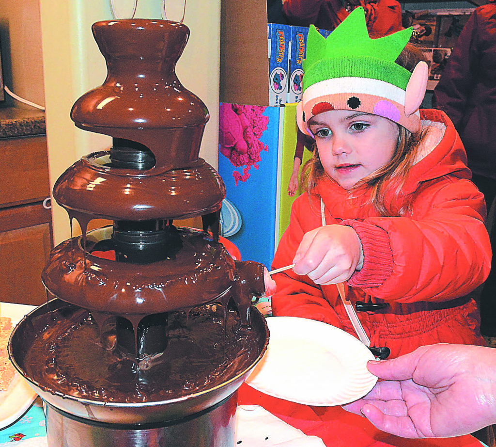 Betty Yagley, 4, of Oxford, drenches a marshmallow in chocolate. Photo by C.J. Carnacchio.
