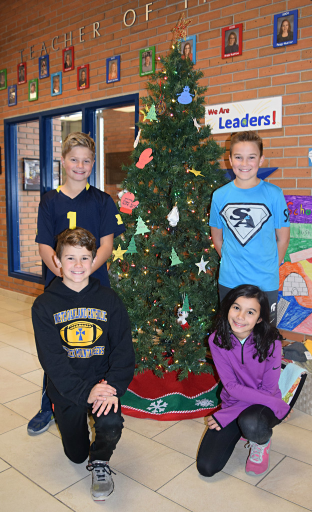 Oxford Elementary Student Council representatives (back left, clockwise) Nolan Mauser, Luke Johnson, Nadia Drobnich and Dominic Cassise pose with the Giving Tree at their school. Giving Trees, like this one, have sprouted at elementary schools throughout Oxford. Photo by Elise Shire.