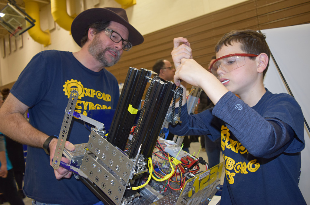 Devon Rippetoe of the Cyborg Cats Team 11231 makes some adjustments to the team’s robot before the competition with the help of Coach Mike Schmalenberg. Photo by Elise Shire.
