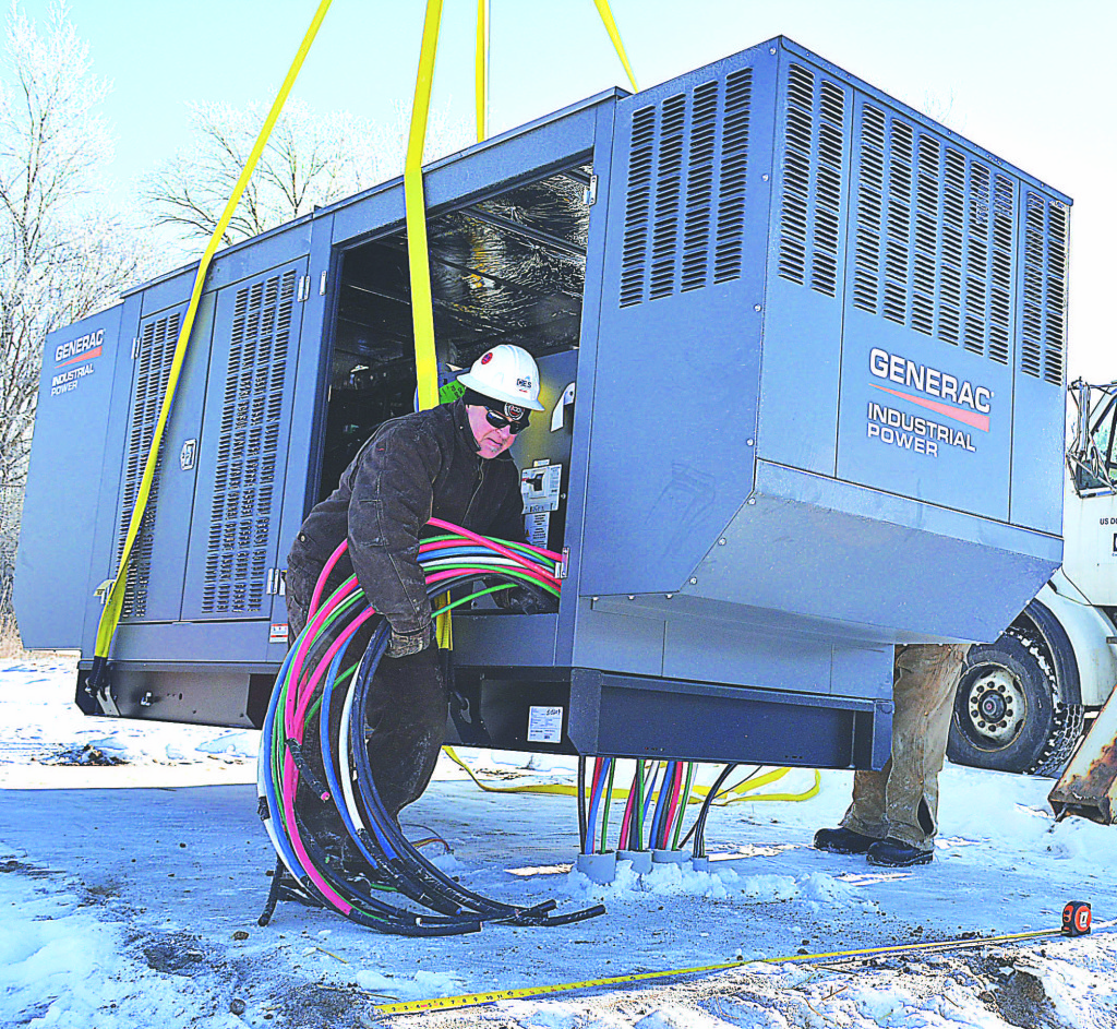 A worker helps install a 250-kilowatt industrial generator that will serve the Oxford Township Hall during power outages. Photo by C.J. Carnacchio.