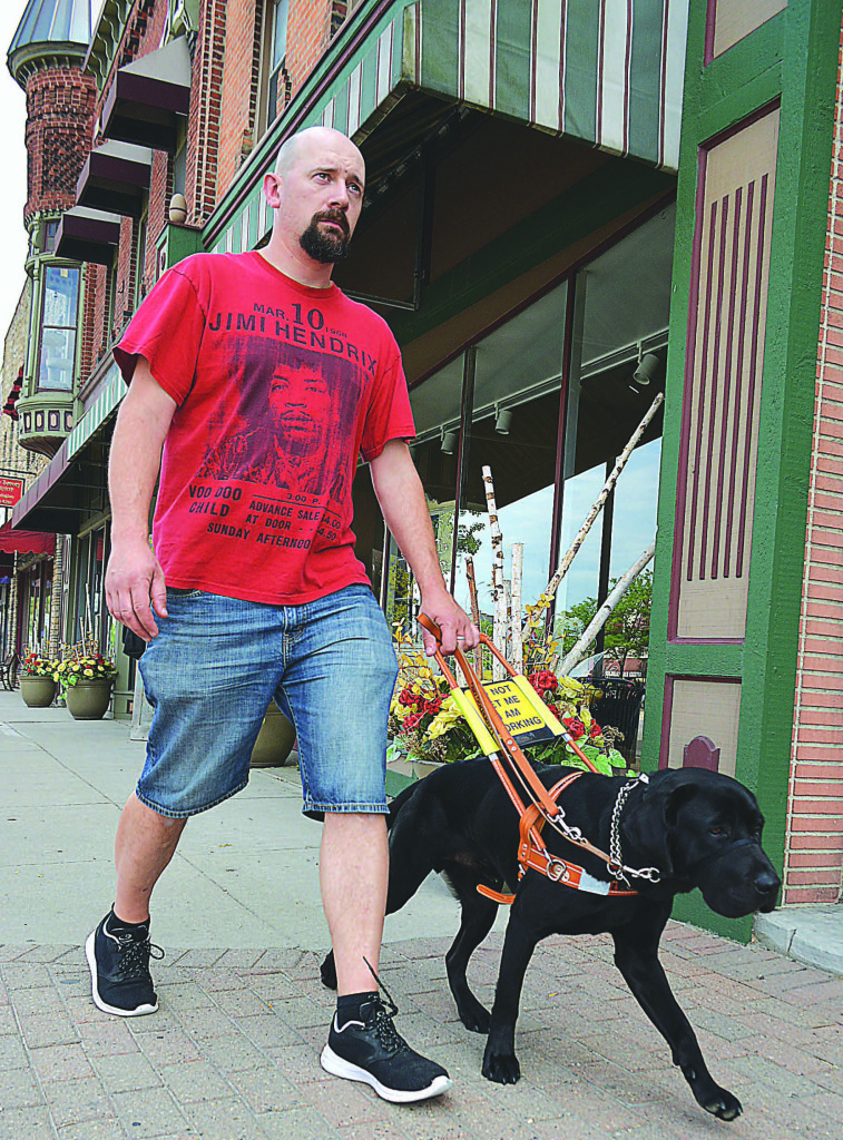 Oxford resident Justin Willcock is legally blind and has hearing loss in both ears. He walks around town with Alex, his guide dog.